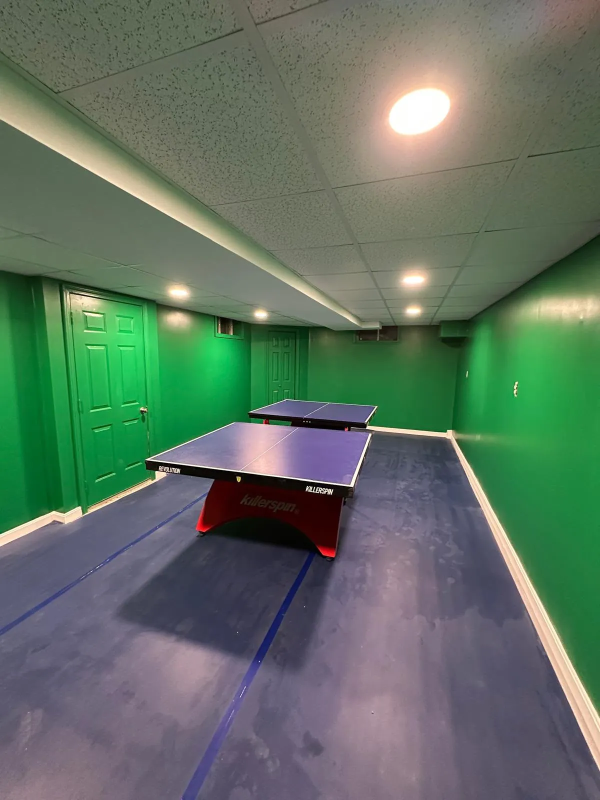 Finished basement rec room with a ping pong table and epoxy floor