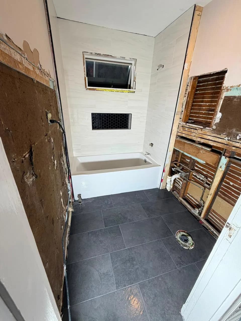 Bathroom opened to the studs with plumbing exposed